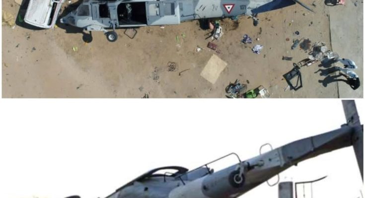 Overturned military helicopter crushing vehicles after crash in a residential area