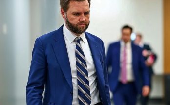 Serious bearded man in blue suit walking hallway