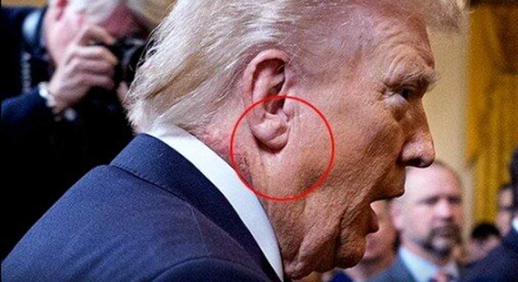 profile of a man speaking at a formal event with focus on ear detail