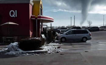 tornado funnel cloud forming behind QI restaurant with snow piles in parking lot