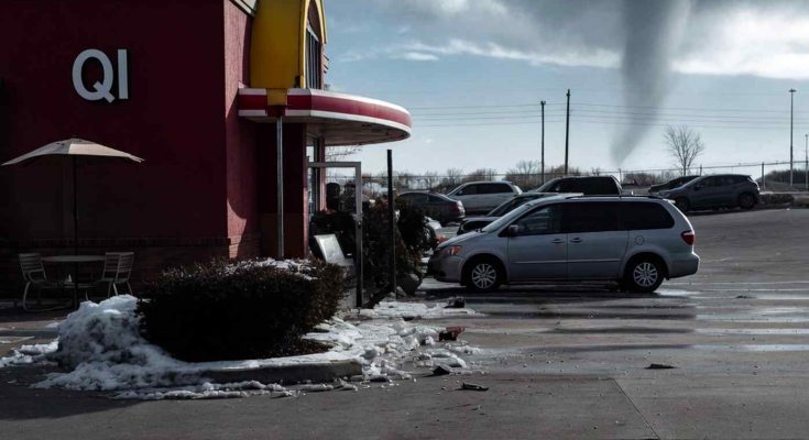 tornado funnel cloud forming behind QI restaurant with snow piles in parking lot