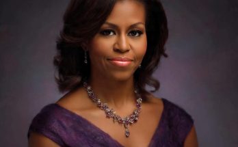 elegant woman in purple dress with necklace, poised expression